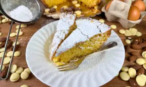 Fette di caprese al limone spolverate di zucchero a velo, con mandorle e gocce di cioccolato bianco.