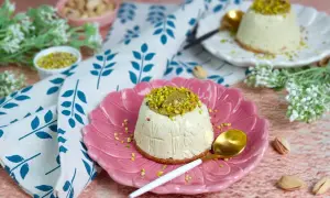 Delizioso semifreddo al pistacchio, guarnito con granella verde brillante, servito su un piatto rosa.