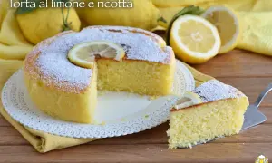 Torta soffice alla ricotta e limone, spolverata di zucchero a velo e decorata con una fetta di limone.