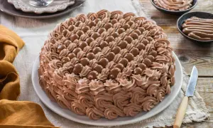 Torta decorata con abbondante crema chantilly al cioccolato e praline. Un dolce invitante pronto per essere gustato.