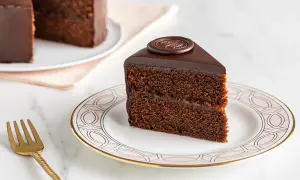 Una fetta di torta Sacher, con la sua glassa lucida e il ripieno di marmellata, mostra i suoi deliziosi ingredienti.