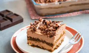 Una fetta di goloso tiramisù al cioccolato e mascarpone, guarnito con riccioli di cioccolato fondente.