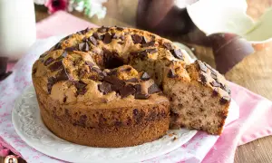 Ciambellone soffice con gocce di cioccolato, perfetto per la colazione di Pasqua. Accanto, uova di Pasqua al cioccolato.