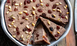 Delizioso castagnaccio con latte, guarnito con pinoli, uvetta e rosmarino. Una ricetta tradizionale per un dolce autunnale.