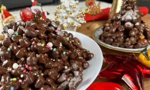 Deliziosi struffoli al cioccolato, decorati con zuccherini colorati e perline argentate, pronti per le feste natalizie.