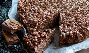 Una golosa torta Mars, con riso soffiato e cioccolato, decorata con caramello e cacao.