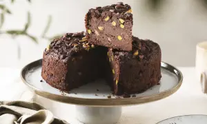 Torta di pane al cioccolato, ricca e golosa, con pistacchi e cacao, servita su un'alzata.