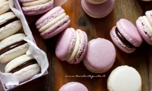 Deliziosi macarons viola e bianchi con ripieno di ganache al cioccolato e crema.