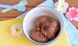 Tre palline di gelato al cioccolato con granella, pronte per essere gustate dopo essere state preparate con la gelatiera.