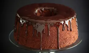 Chiffon cake al cioccolato con glassa lucida che cola. Un dolce invitante su un piatto di vetro.