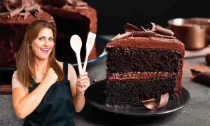 Donna sorridente con mestoli in mano, accanto a una fetta di torta tenerina Bimby, ricca e golosa.