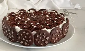 Torta Pan di Stelle decorata con biscotti al cacao e stelline bianche, un dolce che fa sognare.