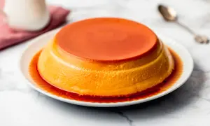 Delizioso creme caramel su un piatto bianco, con sciroppo ambrato che cola sui lati.