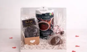 Confezione regalo con cioccolata calda in polvere, cioccolatini e un cuore di cioccolato. Un pensiero goloso, magari con un tocco di cioccolata al sale.