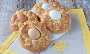 Nidi di Pasqua intrecciati, decorati con codette colorate e uova, pronti per la festa.