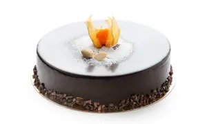Torta rotonda con glassa fondente lucida, decorata con physalis, mandorle e granella di cacao.