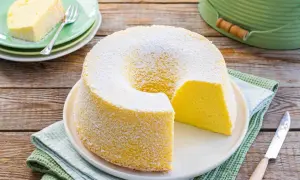 Chiffon cake ricetta originale stampo 24 cm: soffice torta gialla spolverata di zucchero a velo, una fetta servita su un piattino verde.