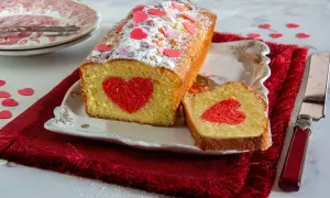 Plumcake farcito con un cuore rosso al centro, decorato con zuccherini a forma di cuore.
