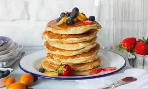 Pancake perfetti, dorati e soffici, pronti per essere gustati. Ecco come fare i pancake per una colazione da campioni, guarniti con frutti di bosco e sciroppo.