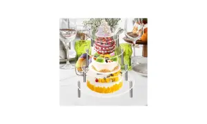 Torta a 3 piani con pan di spagna, decorata con frutta e fiori, su un espositore a più livelli, pronta per una festa.