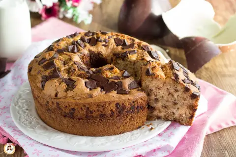 Ciambellone soffice con gocce di cioccolato, perfetto per la colazione di Pasqua. Accanto, uova di Pasqua al cioccolato.