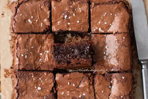 Brownies senza burro, tagliati a quadrotti, con una spolverata di sale grosso. Un morso goloso per ogni fetta.
