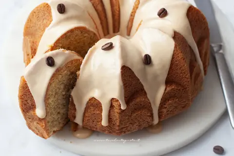 Deliziosa torta al caffè con glassa e chicchi di caffè, una fetta è stata tagliata per mostrare la morbidezza.