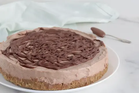 Deliziosa cheesecake alla Nutella con copertura a spirale di cioccolato, pronta per essere gustata.
