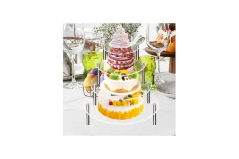 Torta a 3 piani con pan di spagna, decorata con frutta e fiori, su un espositore a più livelli, pronta per una festa.