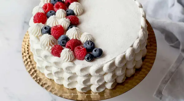 Torta rotonda compleanno decorata con panna, lamponi e mirtilli. Un dolce perfetto per ogni festa.