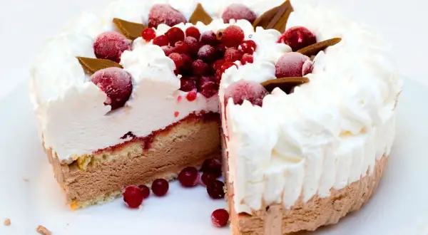 Deliziosa torta gelato a strati con panna montata, frutti di bosco e cioccolato. Perfetta per ogni occasione.