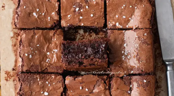 Brownies senza burro, tagliati a quadrotti, con una spolverata di sale grosso. Un morso goloso per ogni fetta.