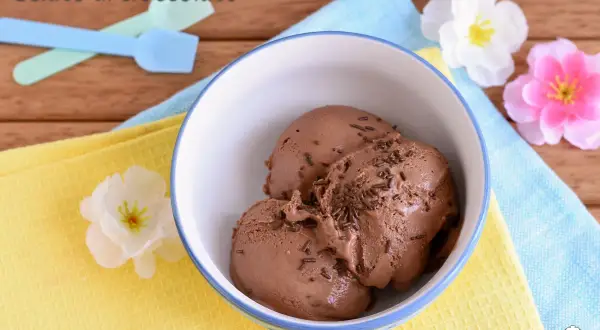 Tre palline di gelato al cioccolato con granella, pronte per essere gustate dopo essere state preparate con la gelatiera.
