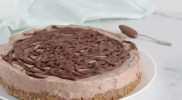 Deliziosa cheesecake alla Nutella con copertura a spirale di cioccolato, pronta per essere gustata.