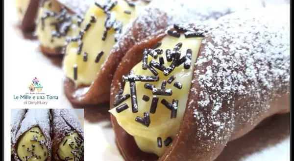 Cannoli siciliani con golosa crema al cioccolato, spolverati di zucchero a velo e granella scura. Un dolce irresistibile!