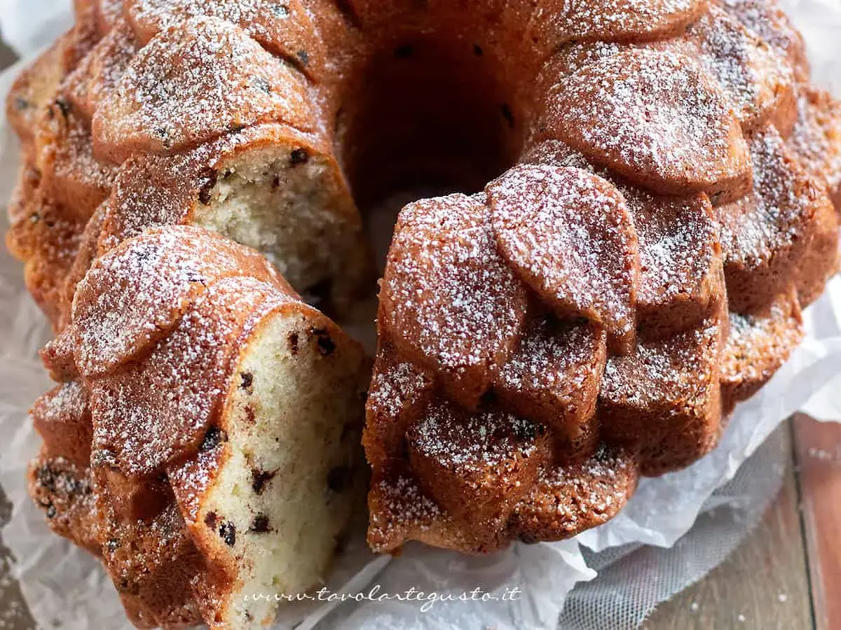 Una deliziosa torta al mascarpone con gocce di cioccolato, spolverata di zucchero a velo, pronta per essere gustata.