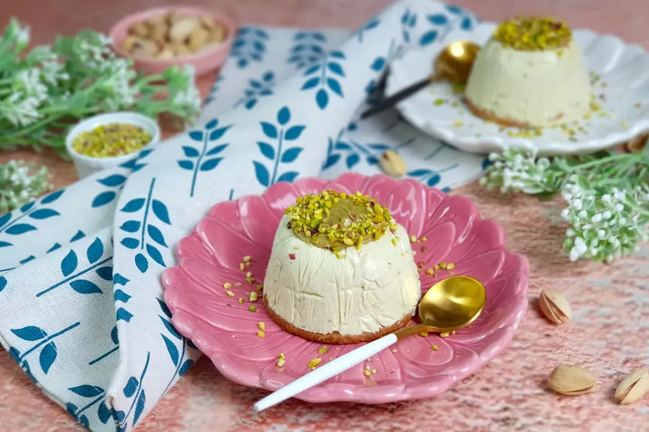Delizioso semifreddo al pistacchio, guarnito con granella verde brillante, servito su un piatto rosa.
