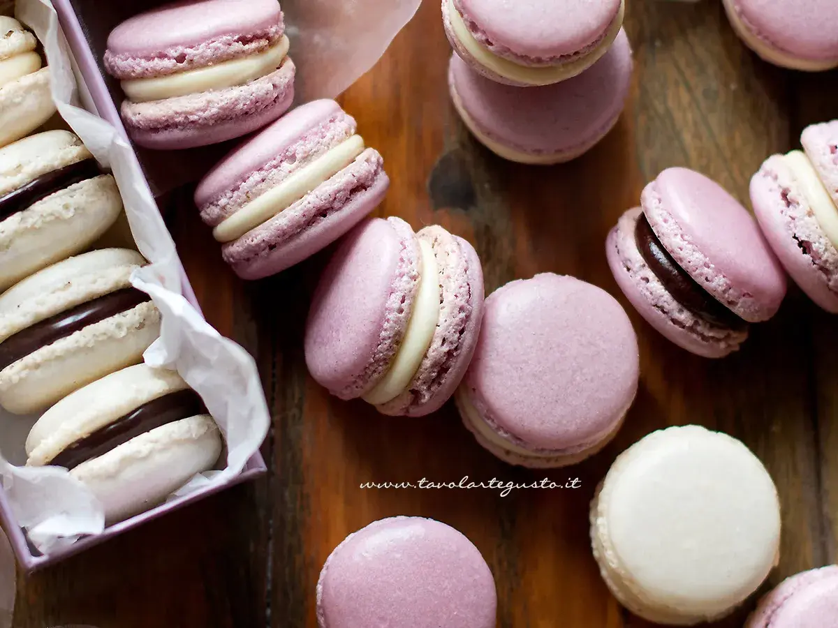 Deliziosi macarons viola e bianchi con ripieno di ganache al cioccolato e crema.