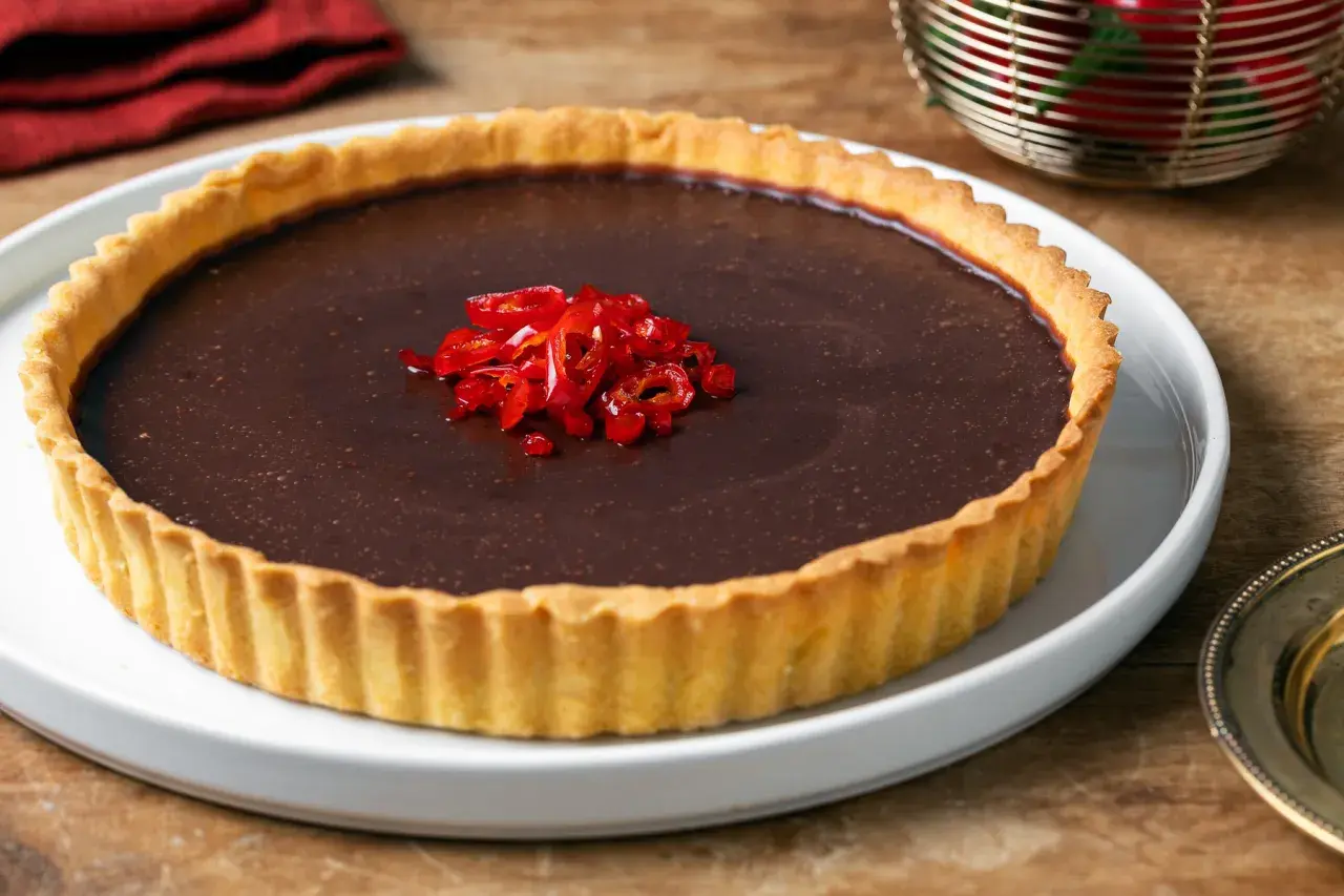 Torta al cioccolato con peperoncino fresco tritato al centro. Un dolce audace che unisce dolcezza e piccantezza.