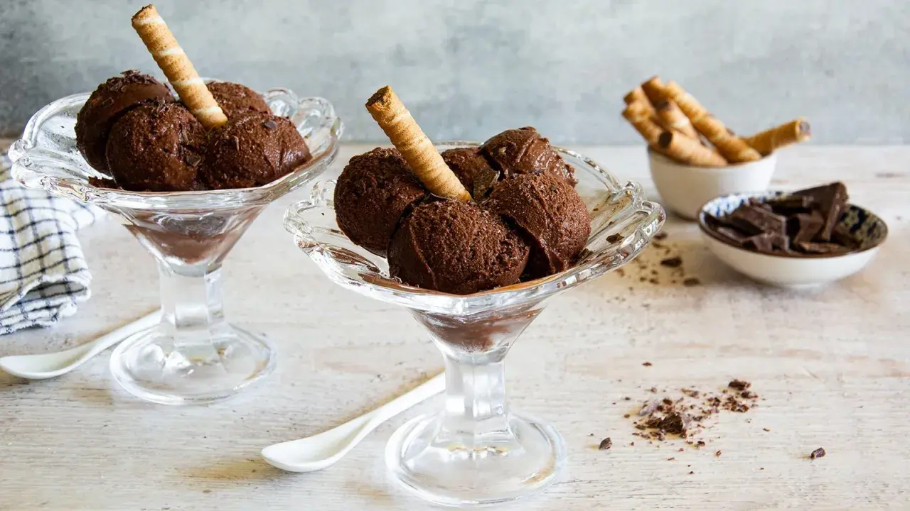 Coppette di granita al cioccolato, guarnite con cialde e scaglie di cioccolato.
