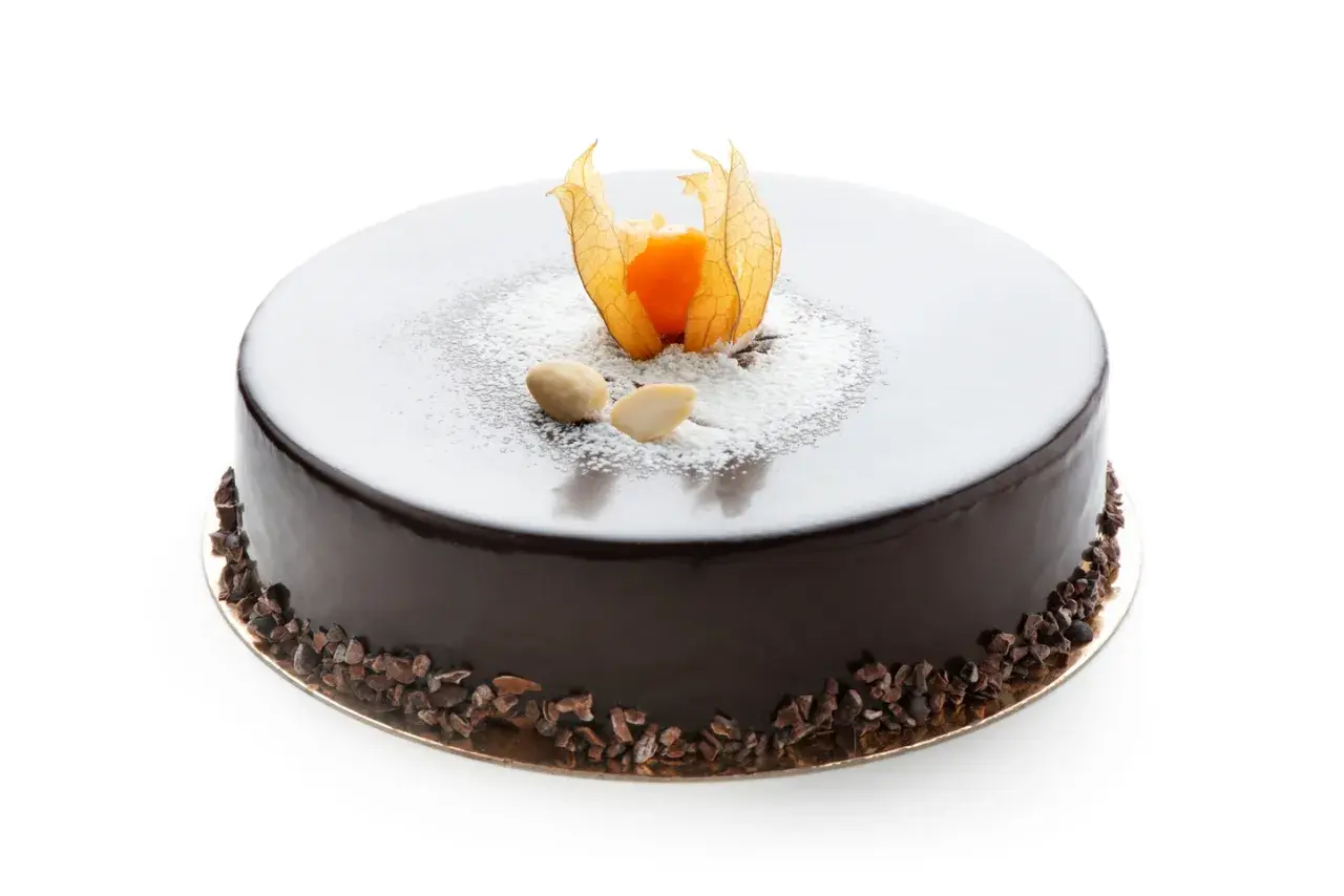 Torta rotonda con glassa fondente lucida, decorata con physalis, mandorle e granella di cacao.
