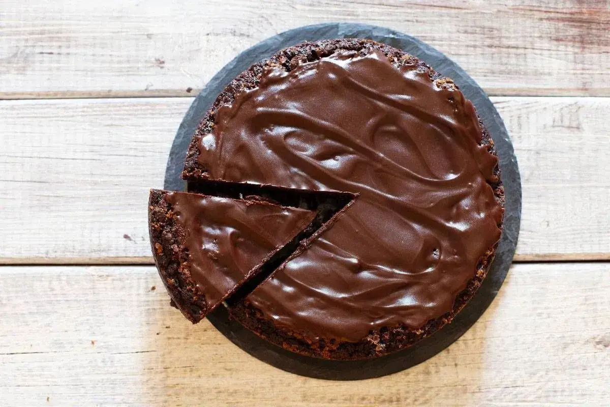 Torta moretta al cioccolato, ricca e golosa, pronta per essere servita a 20 persone. Una fetta è già stata tagliata.