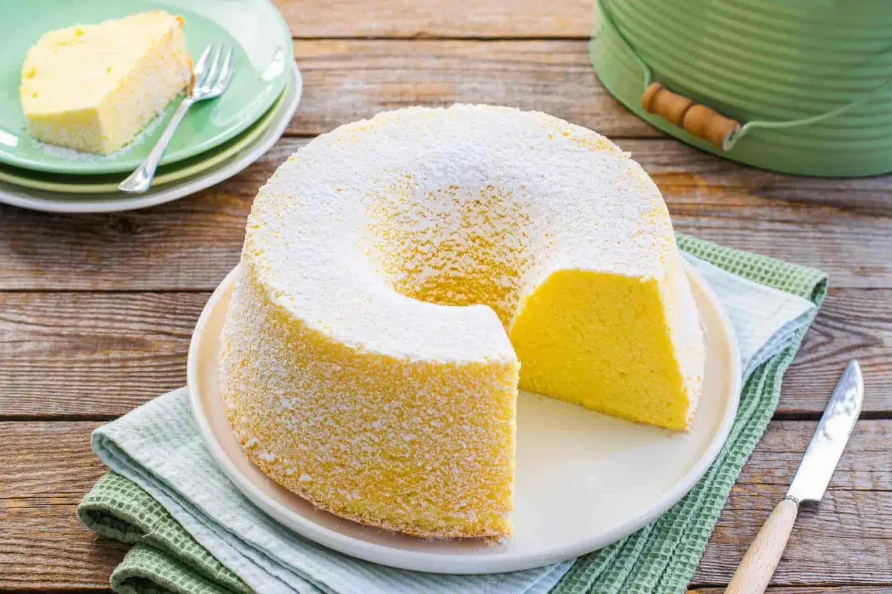 Chiffon cake ricetta originale stampo 24 cm, soffice e spolverato di zucchero a velo, pronto per essere gustato.
