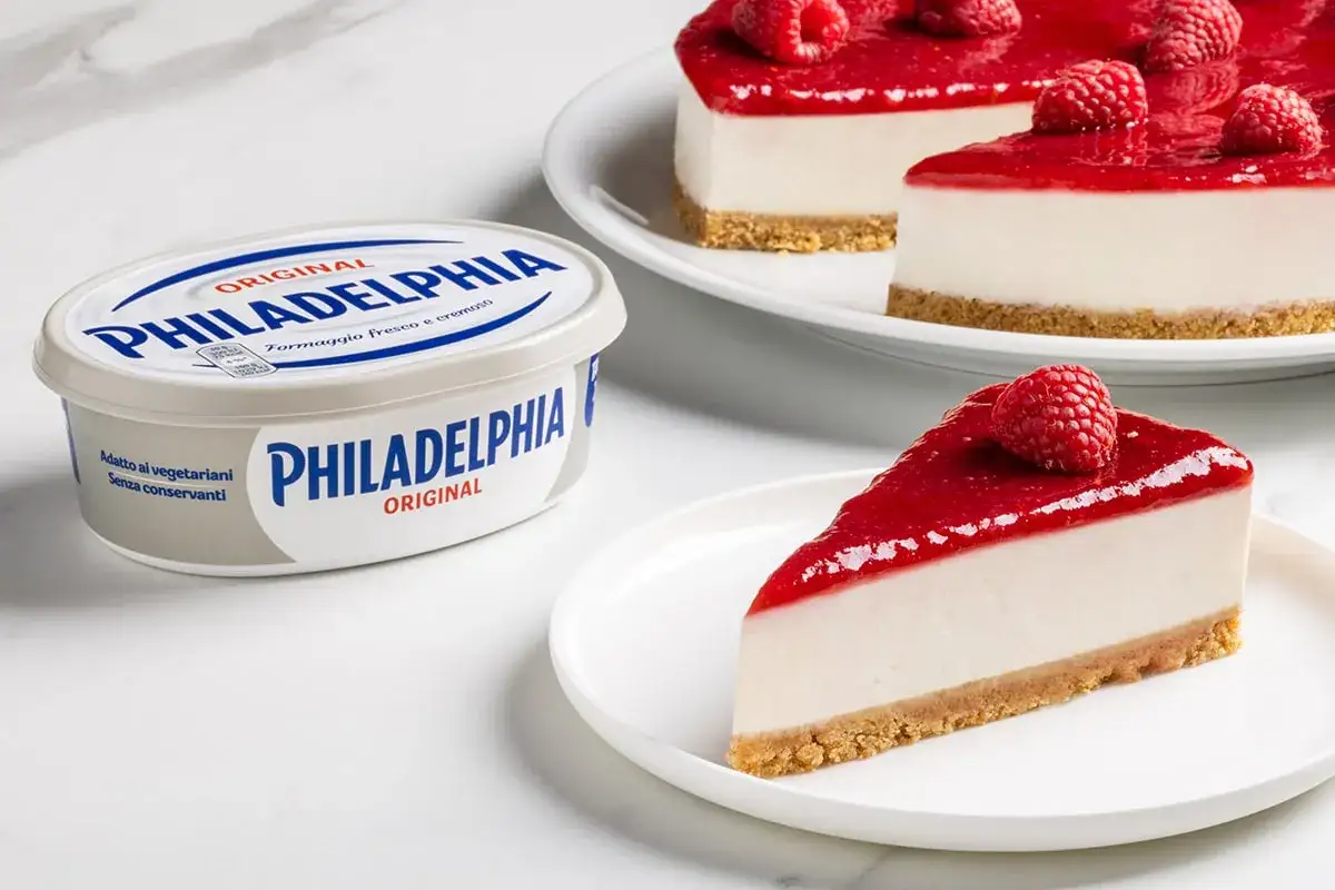 Un delizioso cheesecake alla fragola, preparato con Philadelphia Original, guarnito con lamponi freschi.
