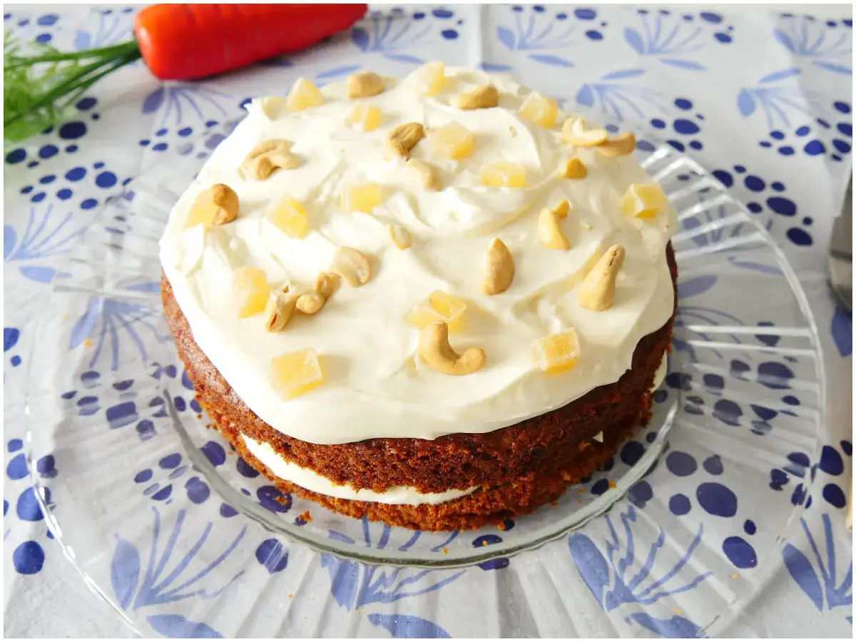 Torta di carote soffice con glassa cremosa, anacardi e cubetti di zenzero candito.