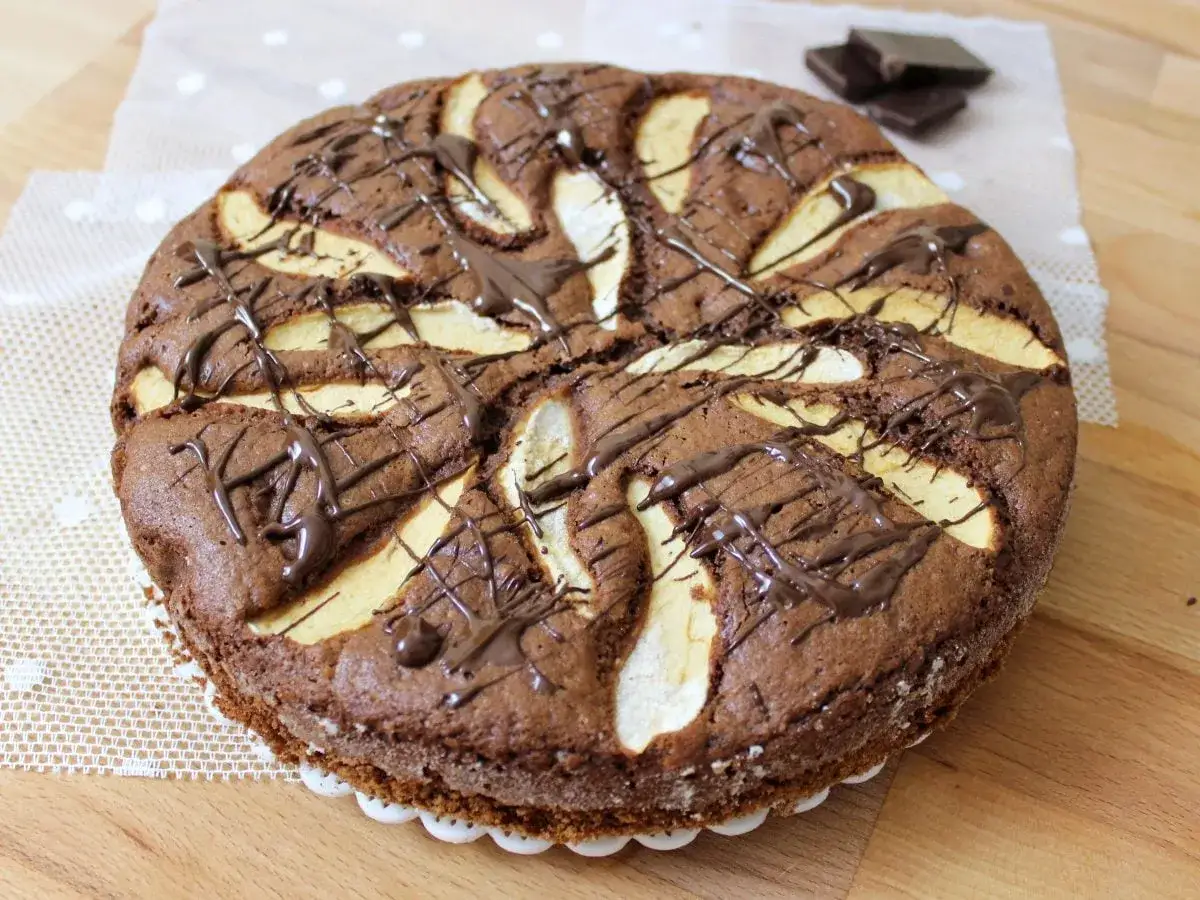 Torta al cioccolato con fette di mela e una golosa glassatura, un dolce perfetto per ogni occasione.