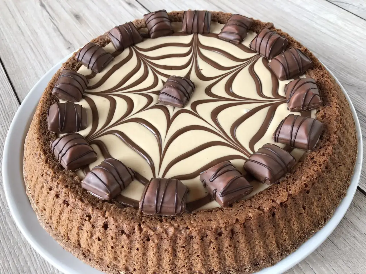 Torta Kinder Bueno con decorazione a ragnatela in cioccolato e pezzi di wafer ricoperti di cioccolato.