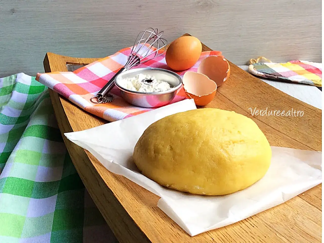 Impasto giallo brillante di pasta frolla con olio, uova e frusta, pronto per essere trasformato in deliziosi dolci.