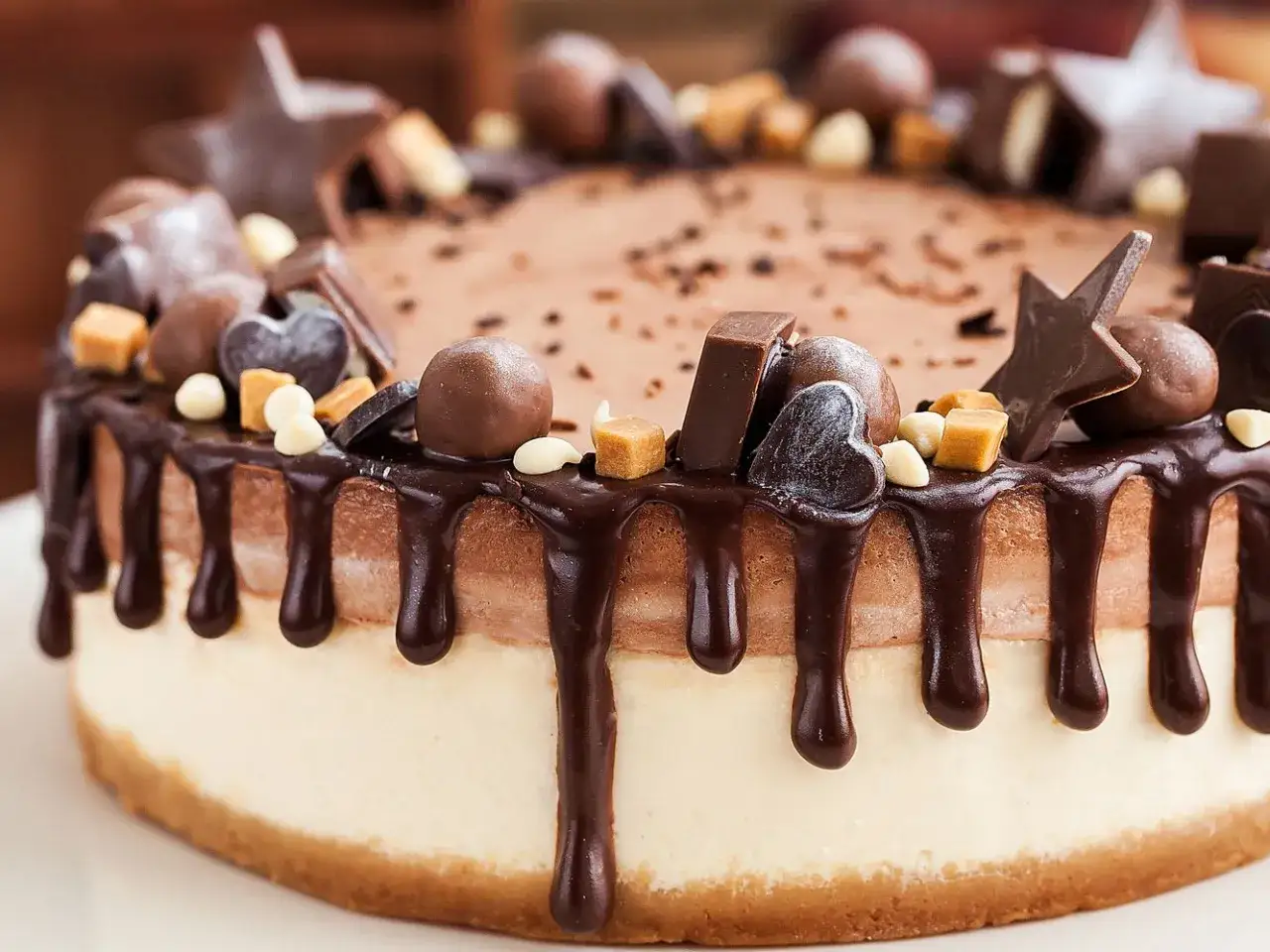 Torta al cioccolato con gocce di caramello e decorazioni a forma di stella e cuore. Un vero capolavoro di cioccolato plastico.