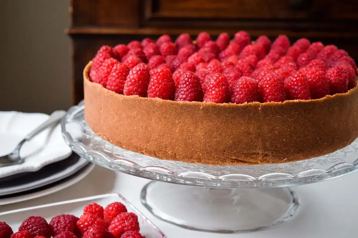 Cheesecake lamponi, un tripudio di freschezza su una base croccante, pronto per essere gustato.